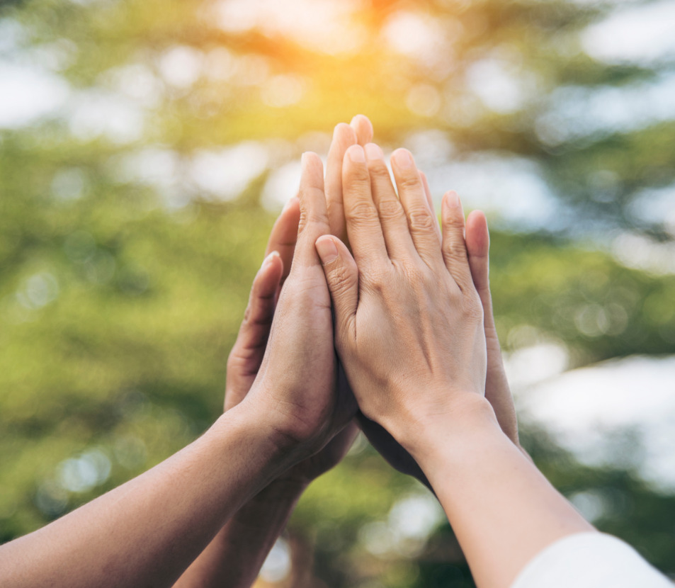 4 Hände die sich zusammen ein High five geben. Es soll den zusammenhalt symbolisieren.